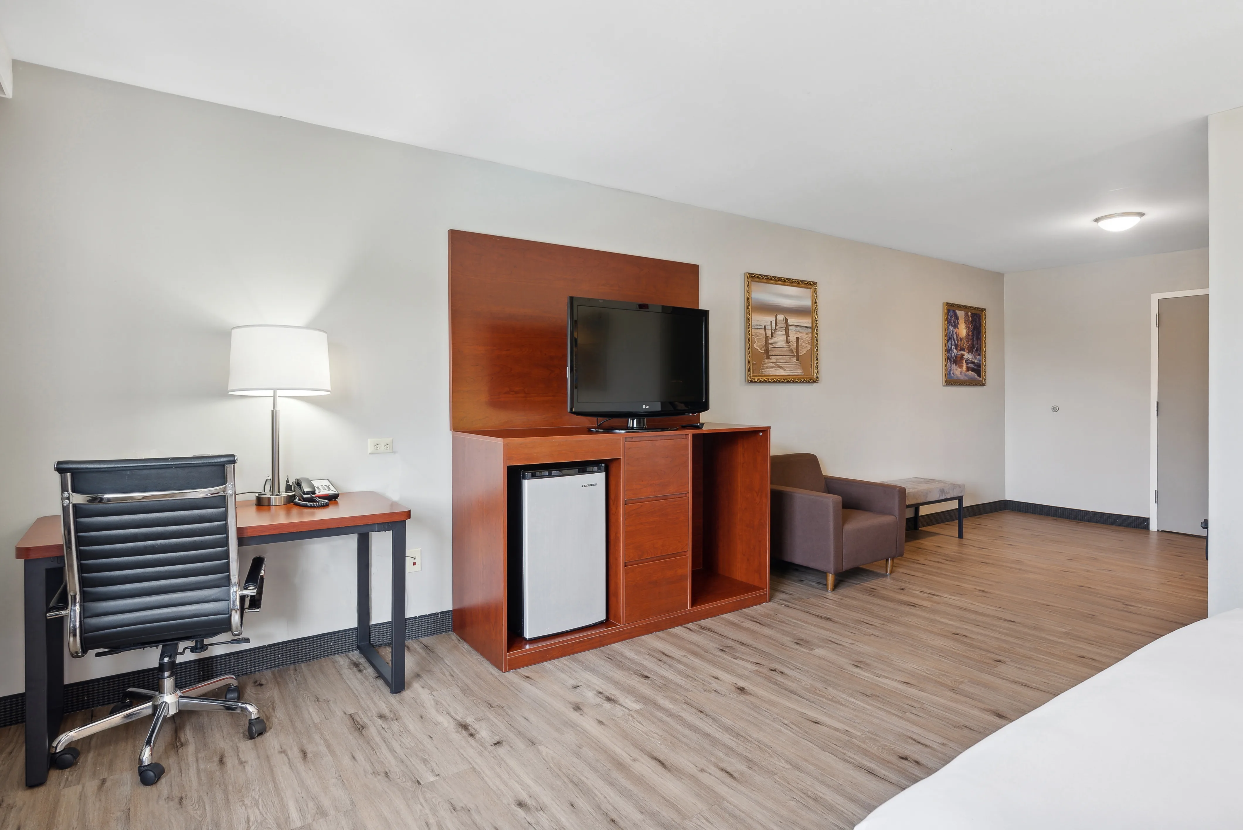 Guest room with television, desk, and couch at Saco Bay Hotel